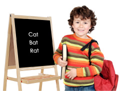 Boy standing by blackboard